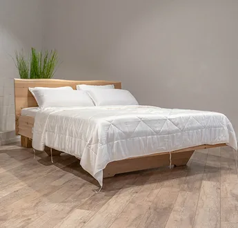 Wit bamboe dekbed op een opgemaakt bed in een slaapkamer