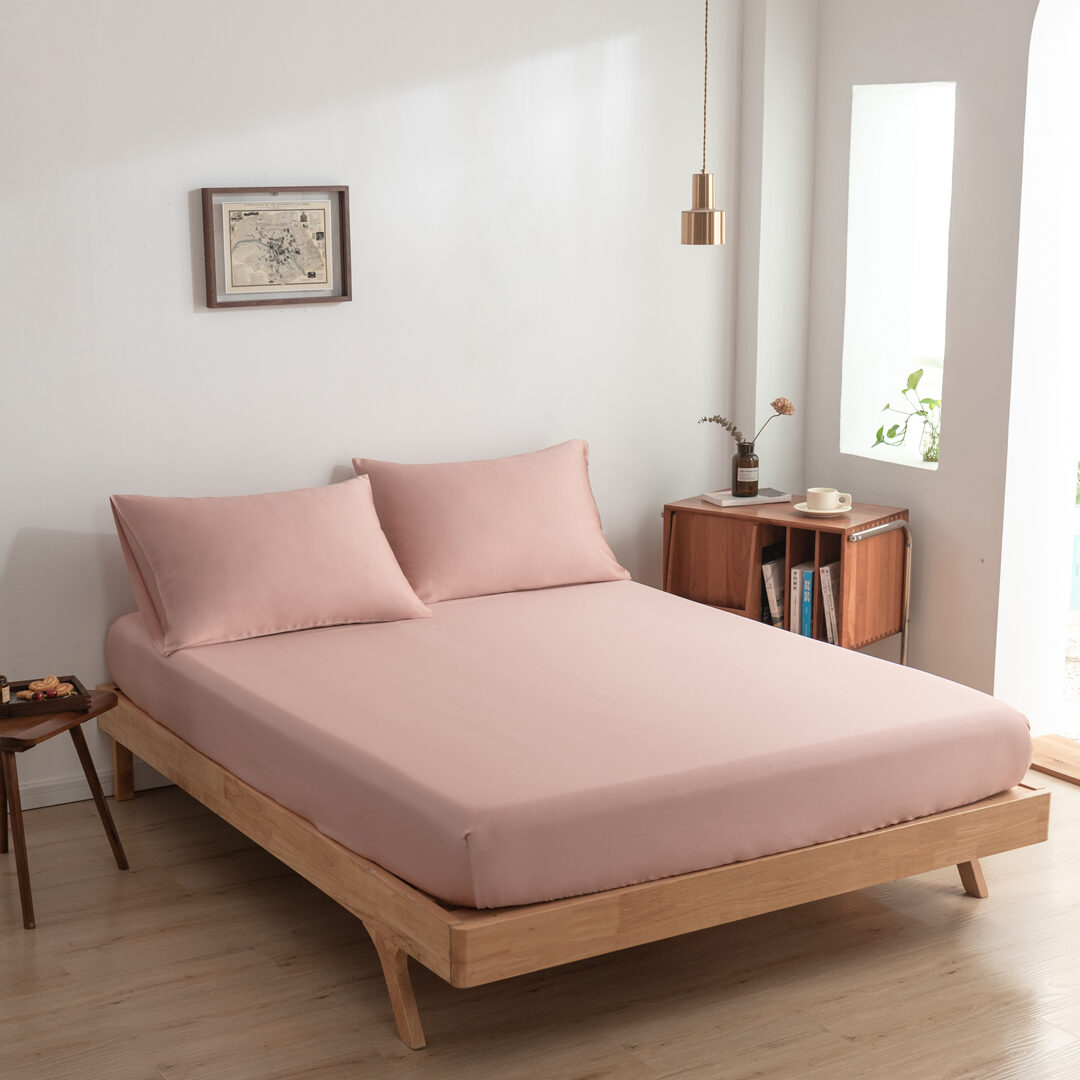 Zijaanzicht bamboe hoeslaken Cuddle Pink (kleur licht roze) op een bed