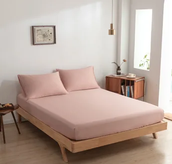 Zijaanzicht bamboe hoeslaken Cuddle Pink (kleur licht roze) op een bed