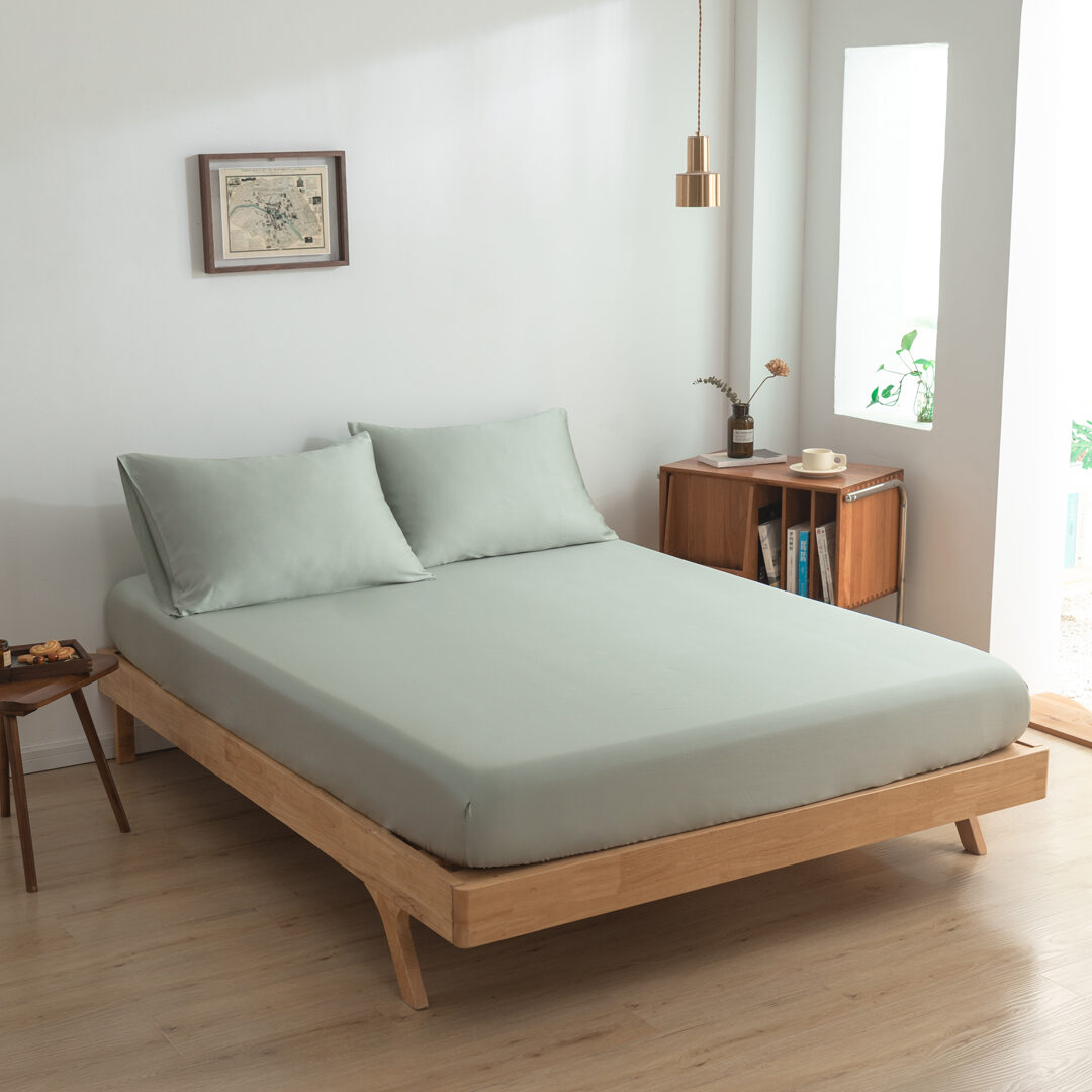 Zijaanzicht bamboe hoeslaken Sage Green (kleur licht groen) op een bed